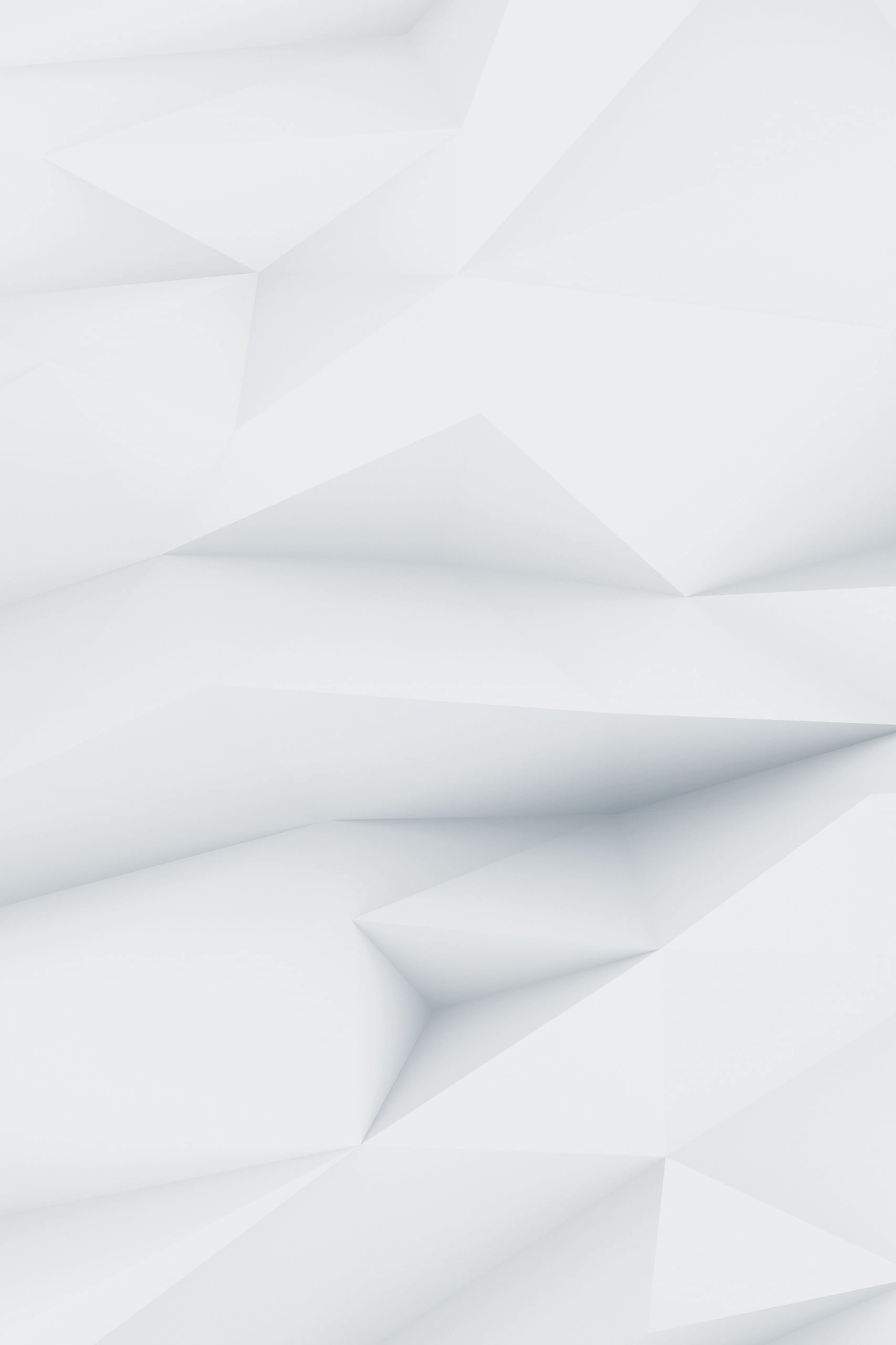 Abstract image of white geometric shapes forming a three-dimensional, faceted surface with soft shadows and clean lines, creating a modern and minimalist look.