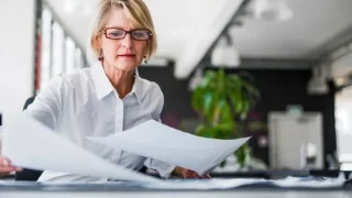 Professional accountant reviewing IRS Form 4562 and equipment receipts for Section 179 deduction calculation